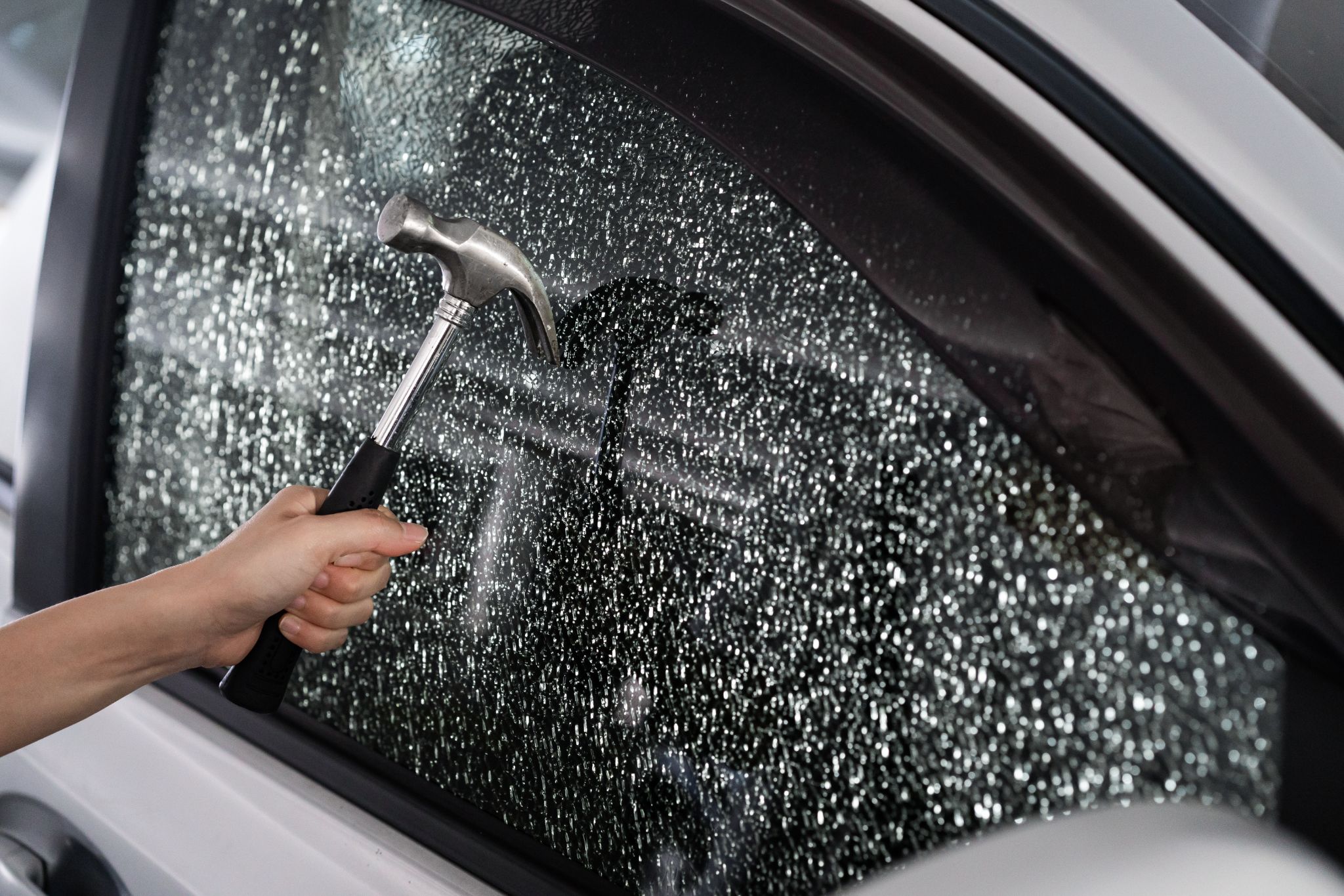 Close,Up,On,Thief,Hand,Breaking,Car,Window,With,Hammer